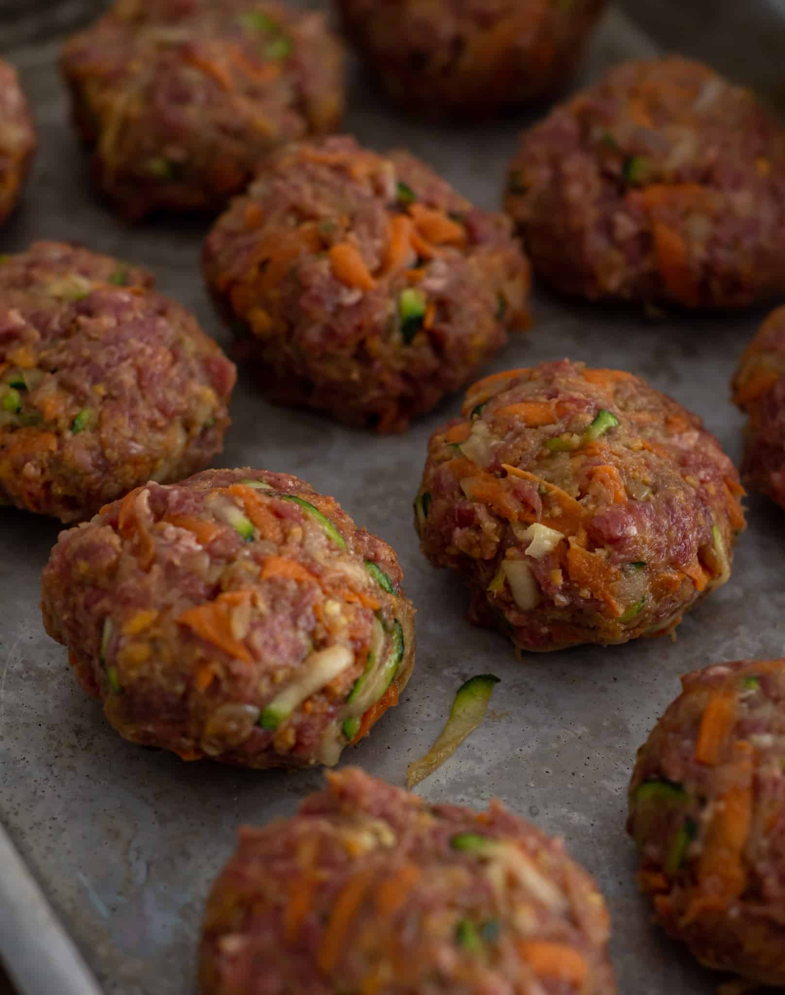 uncooked beef rissoles on a baking tray