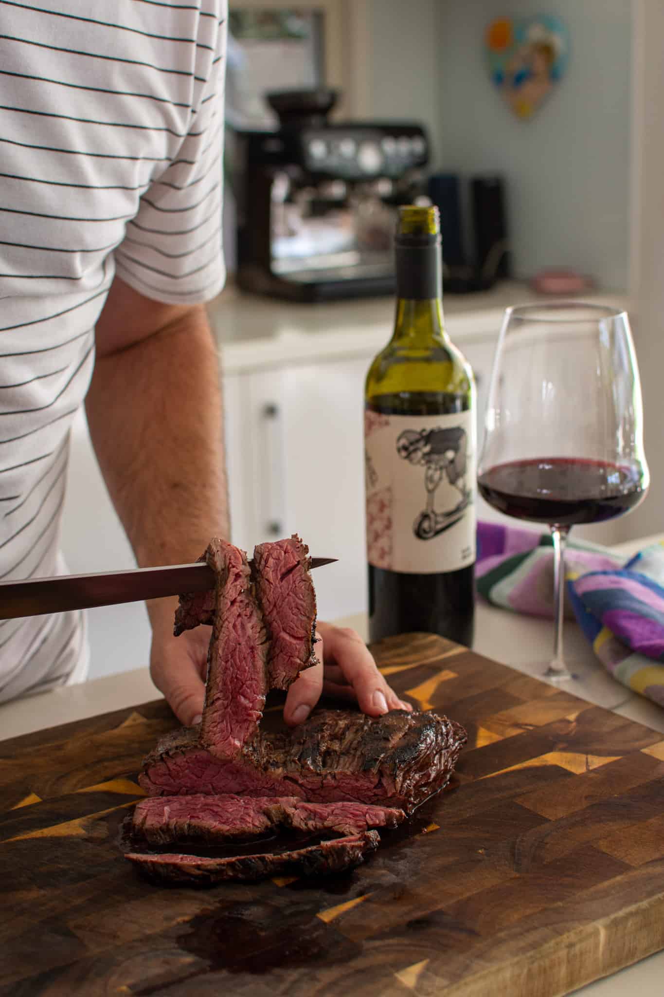 Someone holding up sliced bavette steak using a knife