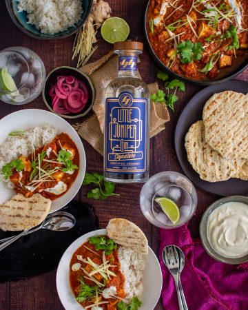 Birdseye view of swordfish curry and a bottle of gin