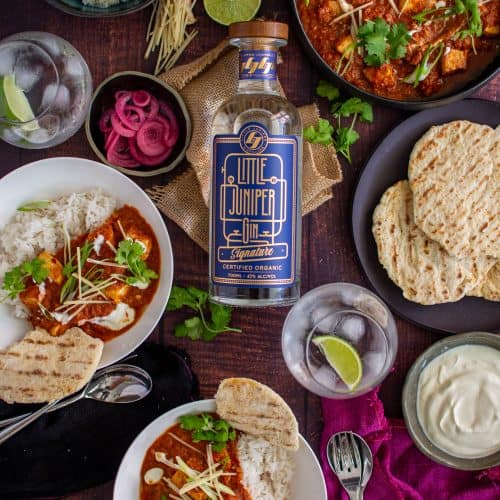 Birdseye view of swordfish curry and a bottle of gin