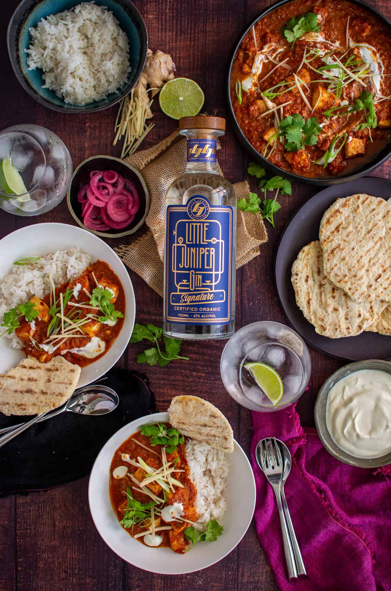 Birdseye view of swordfish curry and a bottle of gin